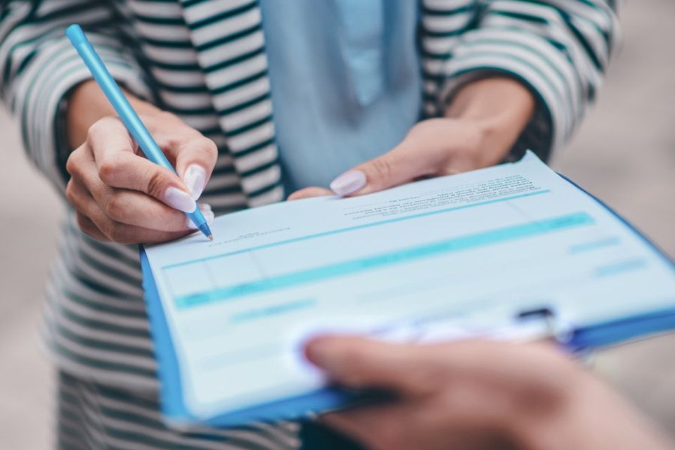 (stock image of person signing document)