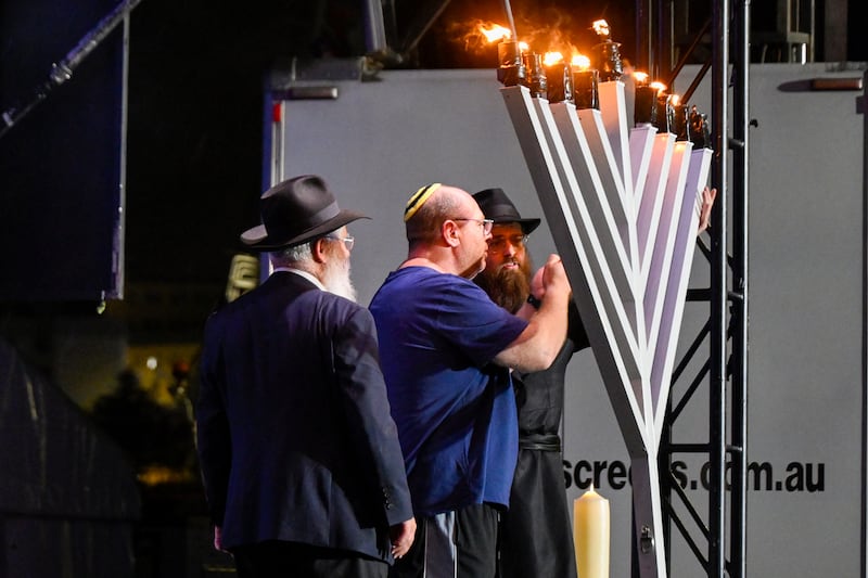 The father of 10-year-old Matilda (centre), who was killed in the shooting on December 14th, lights the eight candle of a menorah during the memorial service on Sunday. Photograph: Izhar Khan/Getty
