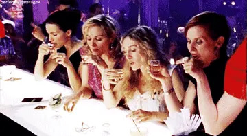 Four women at a bar take shots together, enjoying a lively night out
