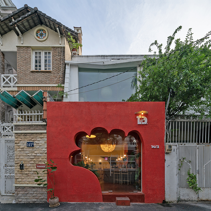 café’s red facade carves welcoming hand-shaped entrance in vietnam