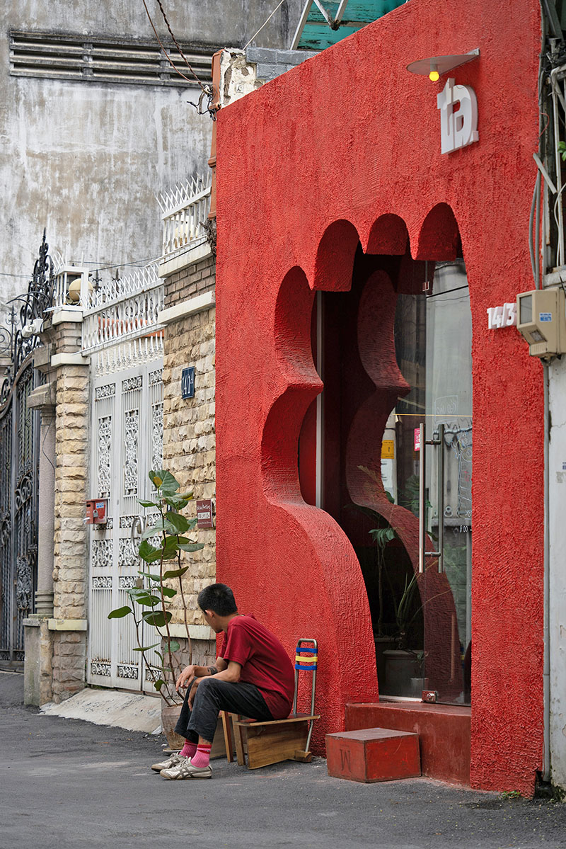 café’s red facade carves welcoming hand-shaped entrance in vietnam