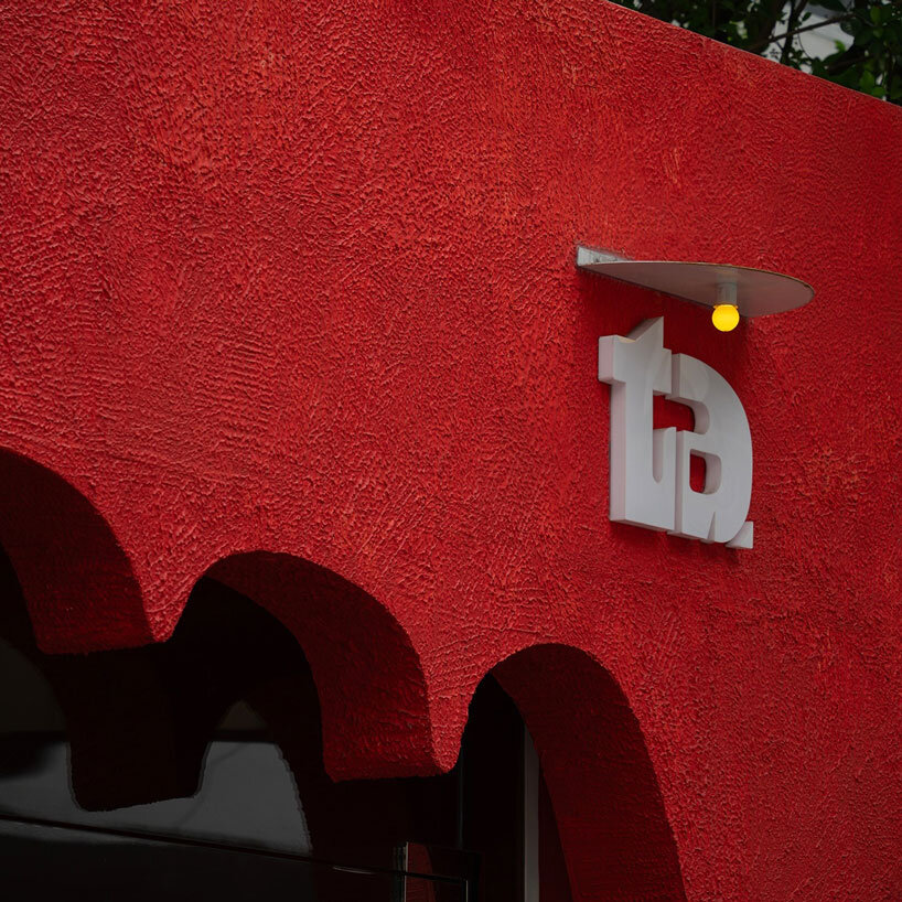 café’s red facade carves welcoming hand-shaped entrance in vietnam