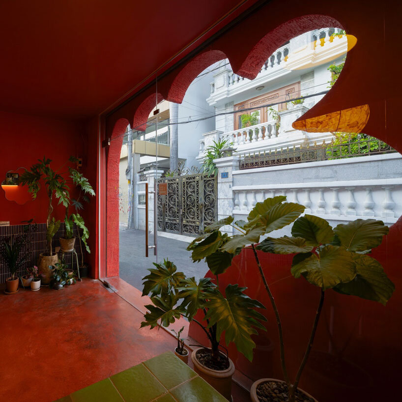 café’s red facade carves welcoming hand-shaped entrance in vietnam