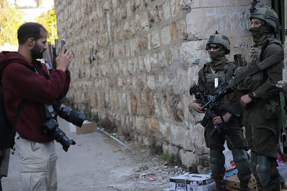 Soldiers block roads and restrict Palestinian movement as illegal Israeli settlers carry out a raid in Hebron, the West Bank on December 20. Photo: Amer Shallodi via Getty