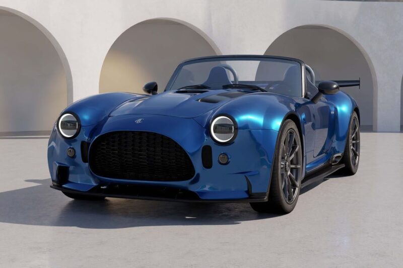 A blue convertible sports car with retro design, inspired by the spirit of 20 Cars That Focused on Analog Engagement in 2025, is parked on a light-colored surface in front of white arched structures.