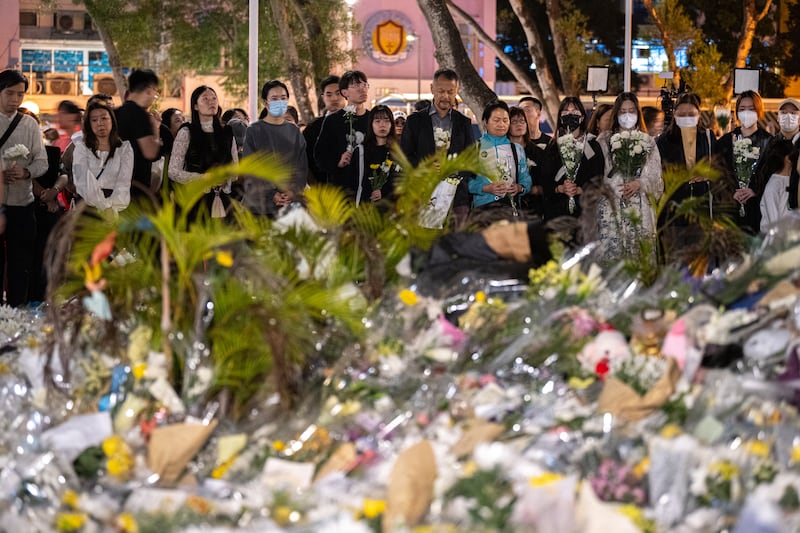 People pray and lay flowers outside the Wang Fuk Court apartment blocks in the aftermath of the deadly fire. Photograph: Philip Fong/AFP/Getty Images