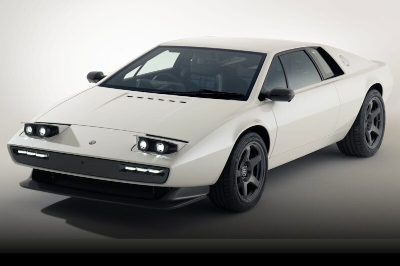 A white, two-door sports car with angular lines, pop-up headlights, and dark alloy wheels—one of the 20 Cars That Focused on Analog engagement in 2025—is parked in a studio setting.