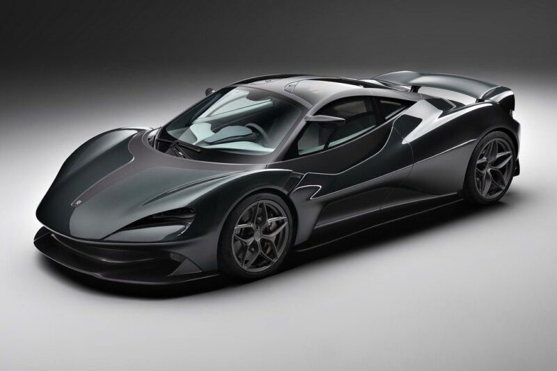 A sleek, dark gray sports car with aerodynamic curves and a low profile, featured among the 20 Cars That Focused on Analog Engagement in 2025, positioned in a well-lit studio setting.