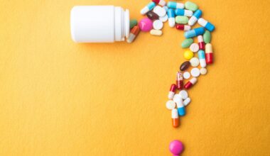 Various colourful medication tablets arranged in the shape of a question mark with a small plastic bottle at the top, against a yellow background.