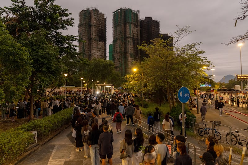 People line up to offer flowers outside Wang Fuk Court in the aftermath of the fire. Photograph: Anthony Kwan/Getty Images