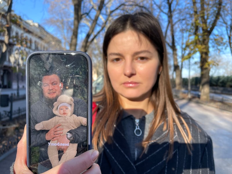 Zhanna Voznyuk in Odesa with a photo of her husband Demyan Hanul and their daughter Sara. Hanul was shot dead in Odesa in March by a Ukrainian soldier who is believed to have been recruited by Russia. Photograph: Daniel McLaughlin