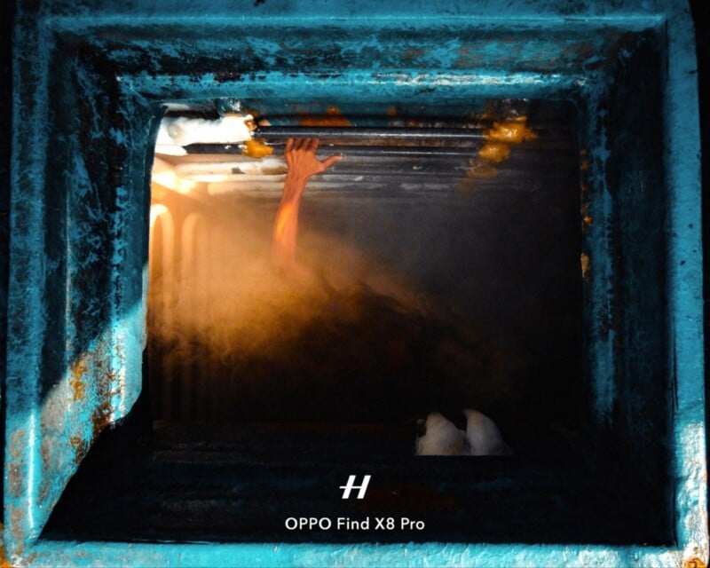 A person’s arm reaches upward through metal bars inside a blue, industrial-looking structure, illuminated by dramatic light and surrounded by mist or steam. The OPPO Find X8 Pro watermark appears at the bottom.
