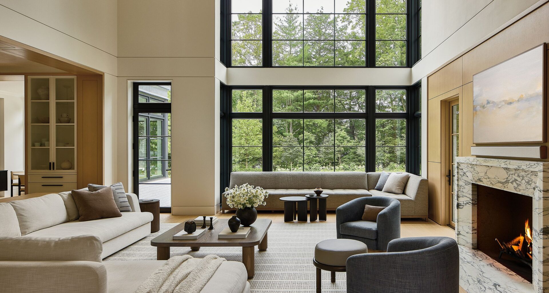 A large living room with double-height ceilings and neutral-toned furniture.