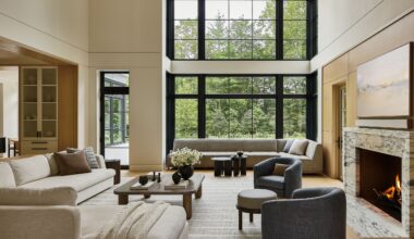 A large living room with double-height ceilings and neutral-toned furniture.