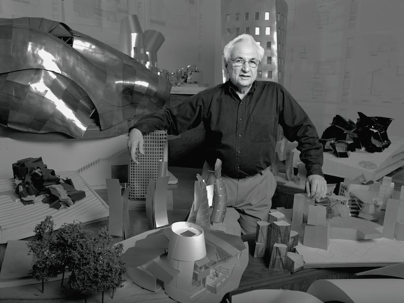Frank Gehry poses with miniatures of his designs in Los Angeles in 1989. Photograph: Bonnie Schiffman/ Getty Images