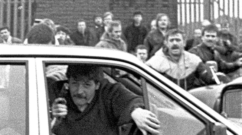 Corporal Derek Woods emerging from his car with his gun in hand after driving into the funeral of Caoimhín MacBrádaigh