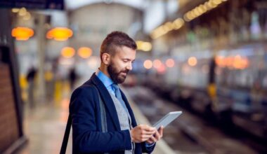 Businessman with tablet, waiting at the train station platform