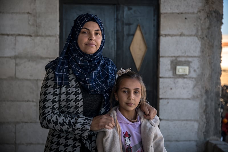 Abdullah's wife Marwa Jamal el-Ali stands with their daughter in Ghabaghib, southern Syria. Photograph: Sally Hayden