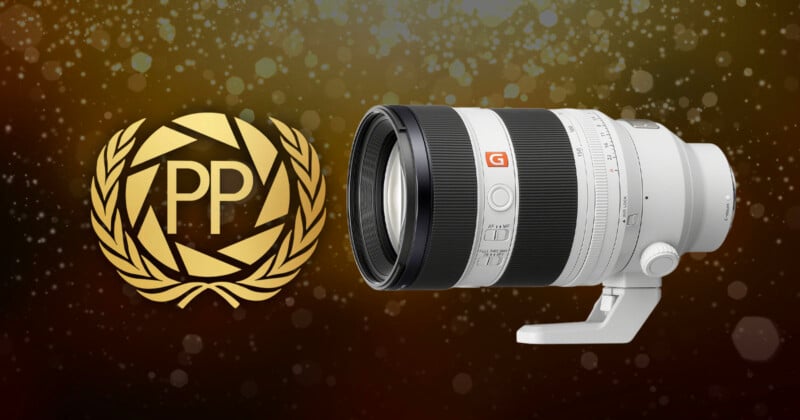 A large white camera lens is displayed on the right, with a gold laurel wreath and the letters "PP" on the left, set against a dark background with sparkling light spots.