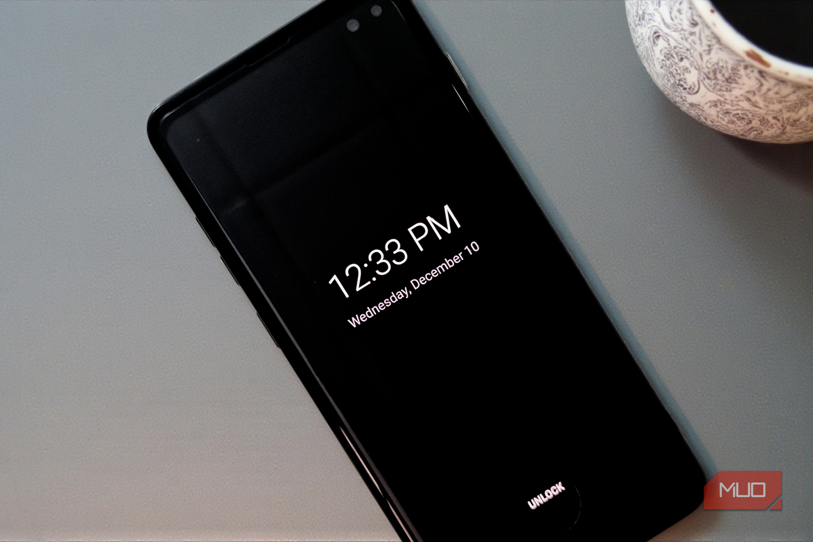 A smartphone with always-on-display lying on a desk.