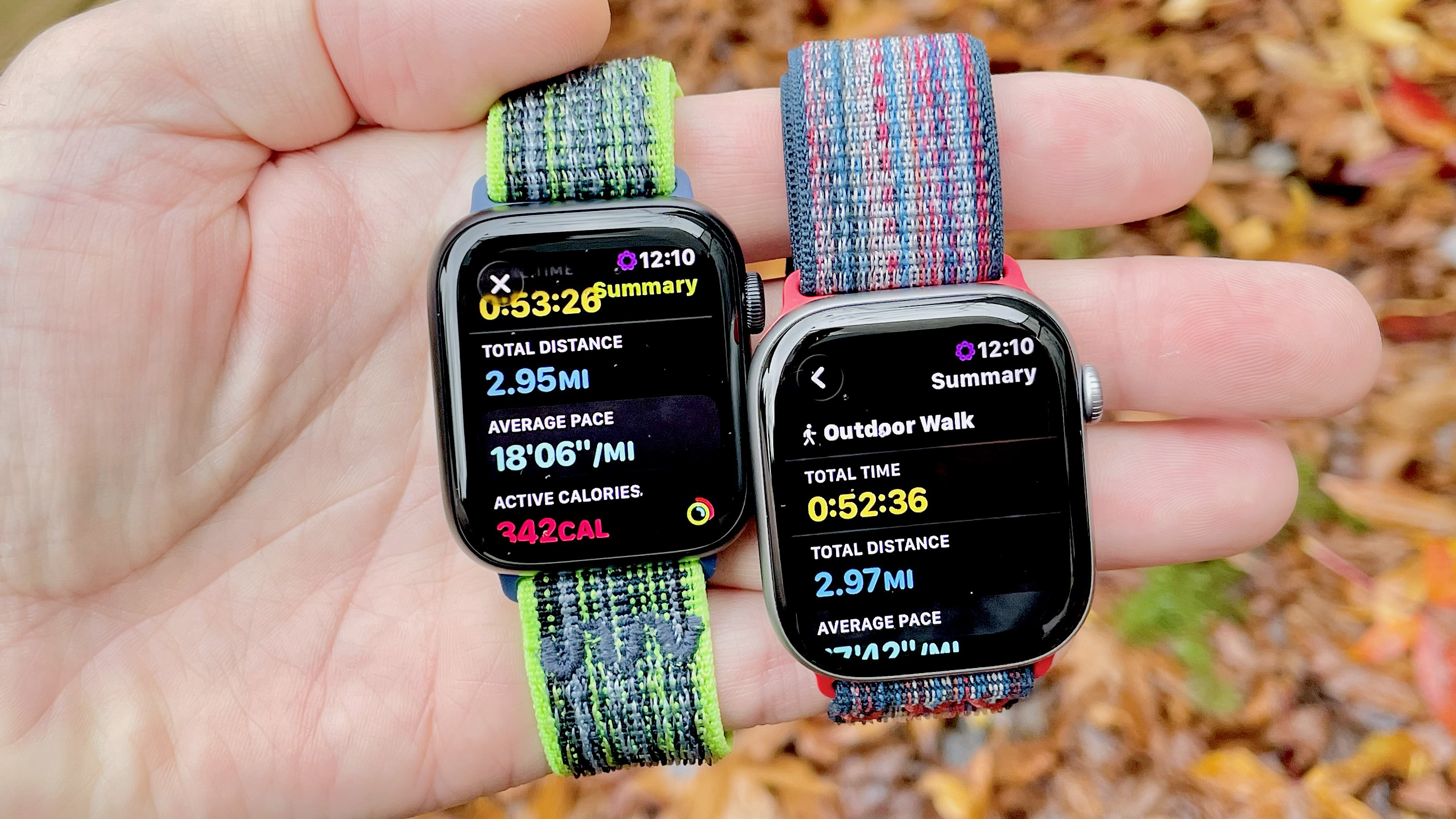 Close-up of the Apple Watch SE 3 and Apple Watch Series 11 in a user's hand with a colorful, out-of-focus background