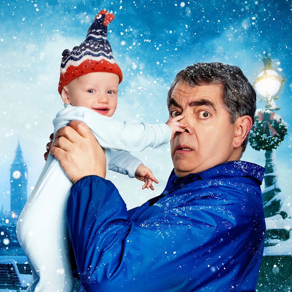 father holding a child in winter attire under snow with a festive background father holding a child in winter attire under snow with a festive background