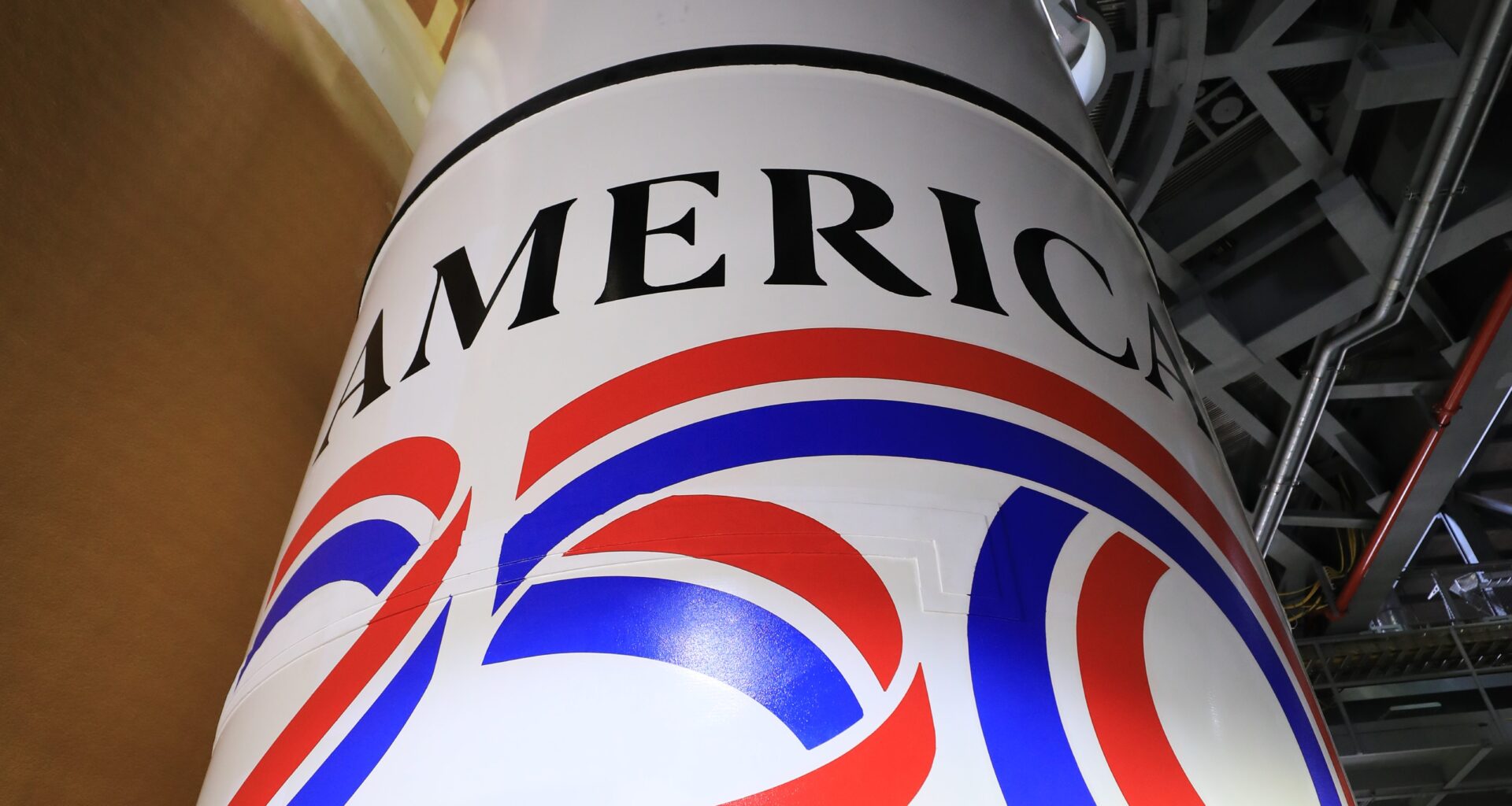 Image shows the America 250 logo in black, red, blue colors painted on the white solid rocket boosters of NASA's SLS (Space Launch System) rocket at NASA's Kennedy Space Center in Florida on Dec. 1, 2025.