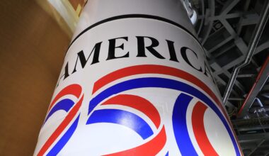 Image shows the America 250 logo in black, red, blue colors painted on the white solid rocket boosters of NASA's SLS (Space Launch System) rocket at NASA's Kennedy Space Center in Florida on Dec. 1, 2025.