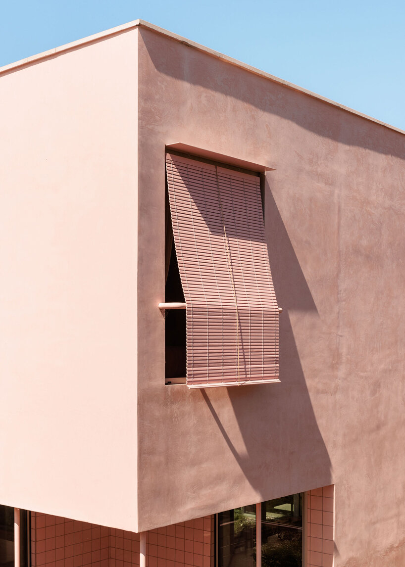 atelier RUA's light pink house contrasts with surrounding greenery in portugal