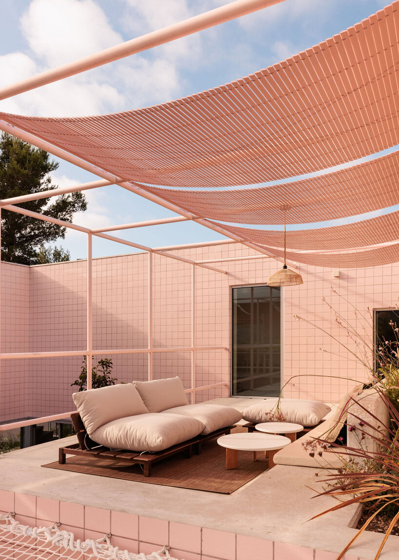 atelier RUA's light pink house contrasts with surrounding greenery in portugal