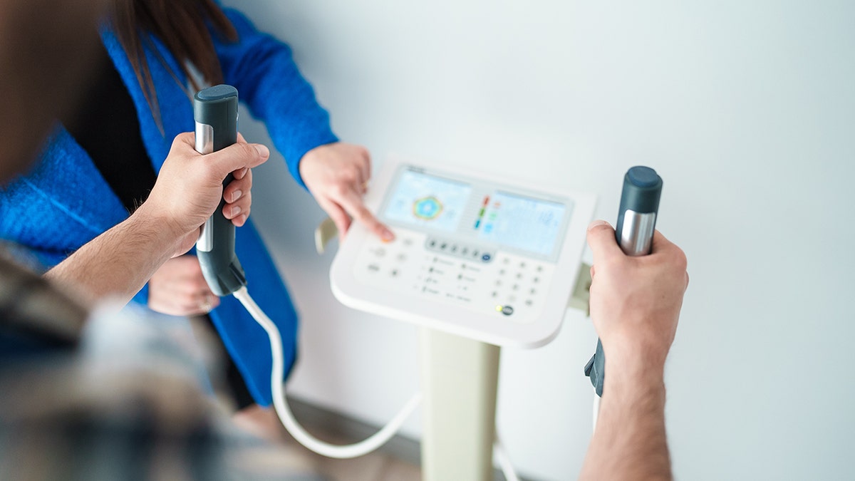 man holds body composition machine