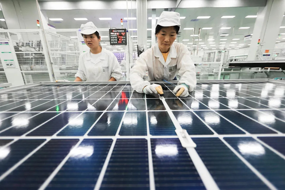 Workers check solar cells in a factory in China in 2025.