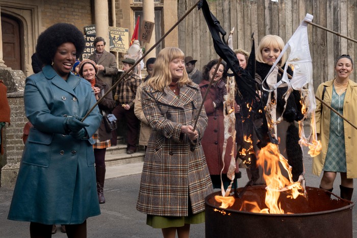 Renee Bailey as Joyce Highland, Natalie Quarry as Rosalind Clifford and Helen George as Trixie Franklin in Call the Midwife Helen George as Trixie Franklin, Natalie Quarry as Rosalind Clifford and Renee Bailey as Joyce Highland in Call the Midwife, burning their bras on a fire pit in the street.