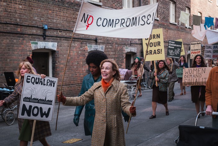 Laura Main as Shelagh Turner in Call the Midwife Laura Main as Shelagh Turner in Call the Midwife, marching down the street with other women, holding a sign that reads 'NO COMPROMISE'.