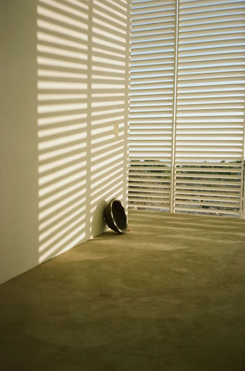 white louvers craft perforated facade filtering daylight within casa nada’s interiors in mexico