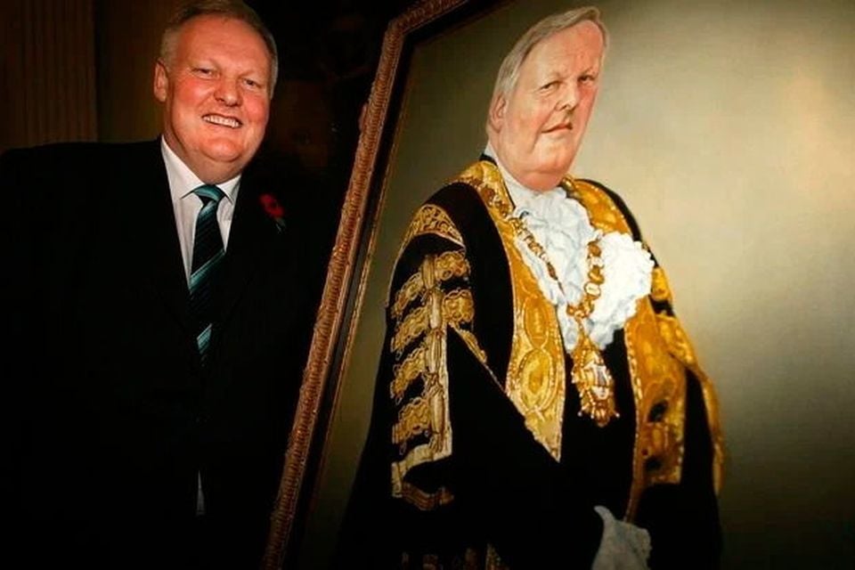 Wallace Browne alongside the portrait that was damaged in the incident