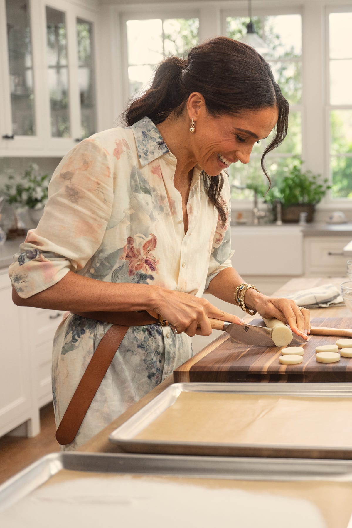A person slicing food in a bright kitchen setting.