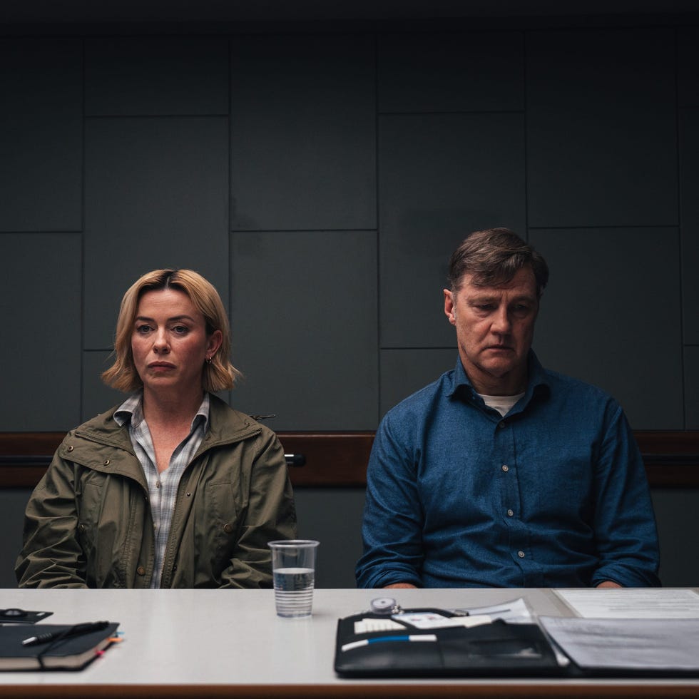 two individuals seated at a table in a room accompanied by various documents two individuals seated at a table in a room accompanied by various documents