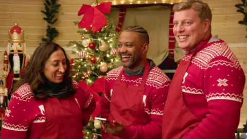 Shazia Mirza, JB Gill and Tom Skinner wearing Christmas jumpers on a festive special of the Apprentice