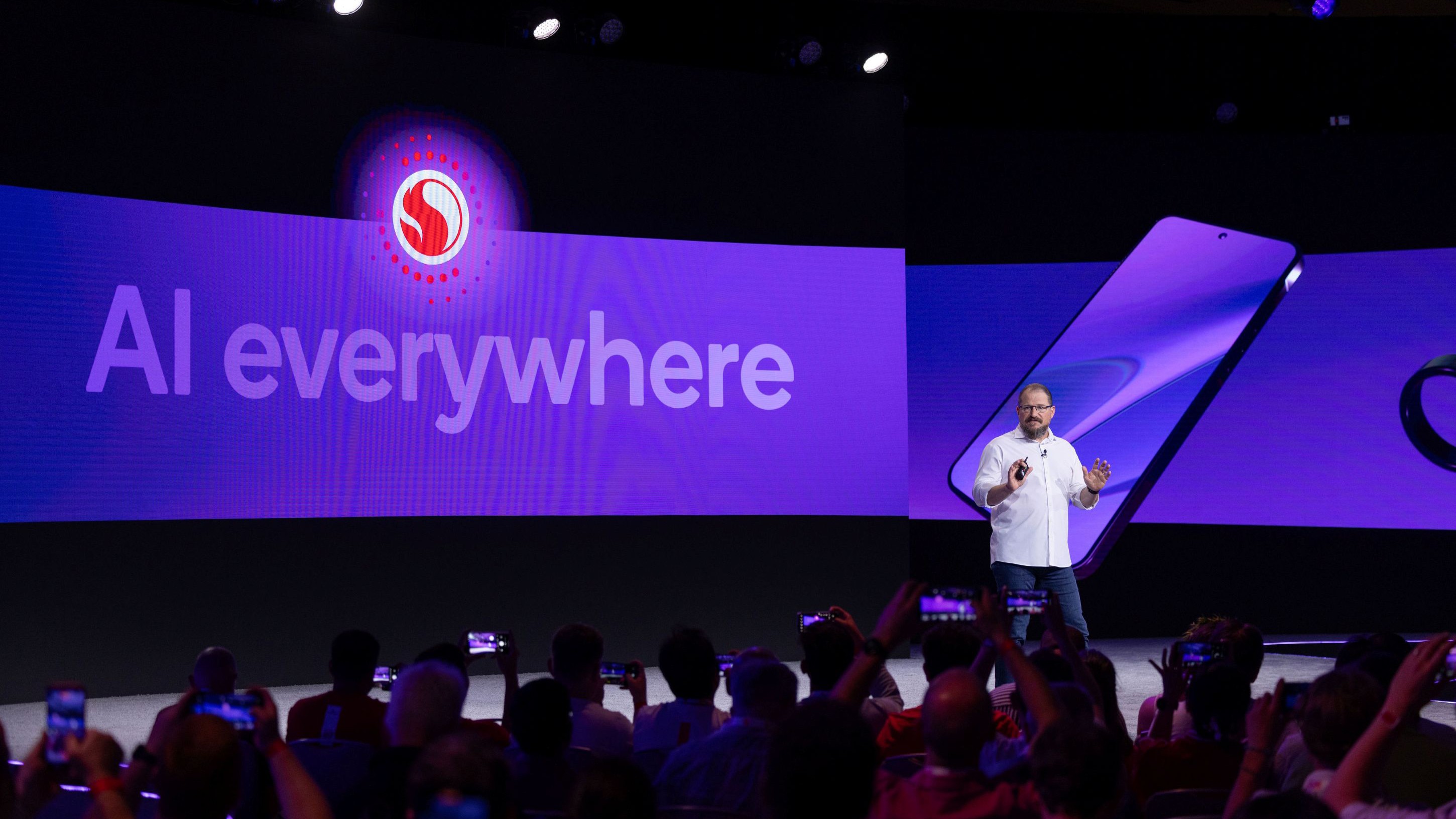 Cristiano Amon on stage with "AI everywhere" behind him