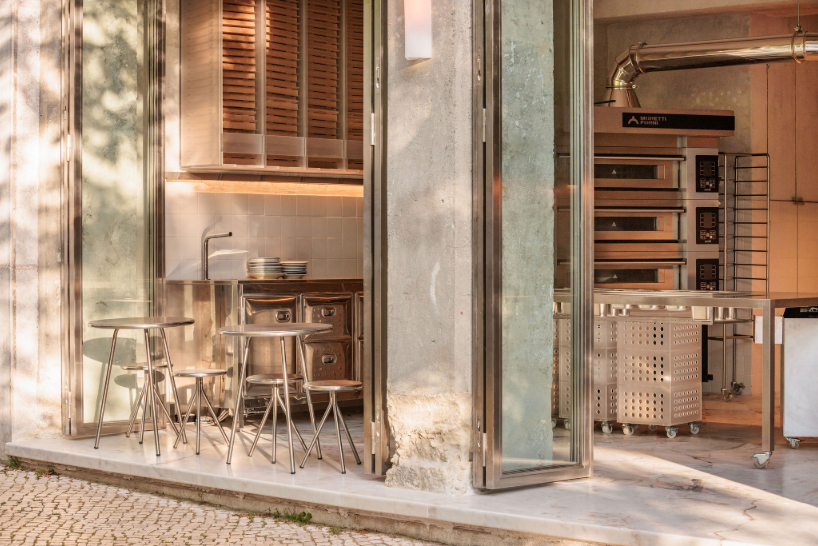 reflective steel interiors and open facade bring lisbon’s street activity into pizza restaurant
