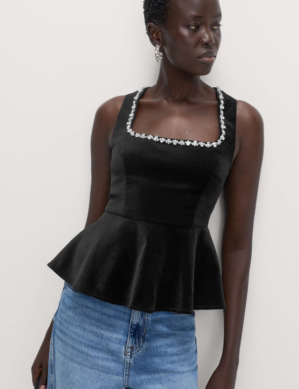 Stylish black sleeveless top with peplum design and embellished neckline stylish black sleeveless top with peplum design and embellished neckline