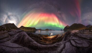 A colorful aurora borealis captured over a rocky landscape