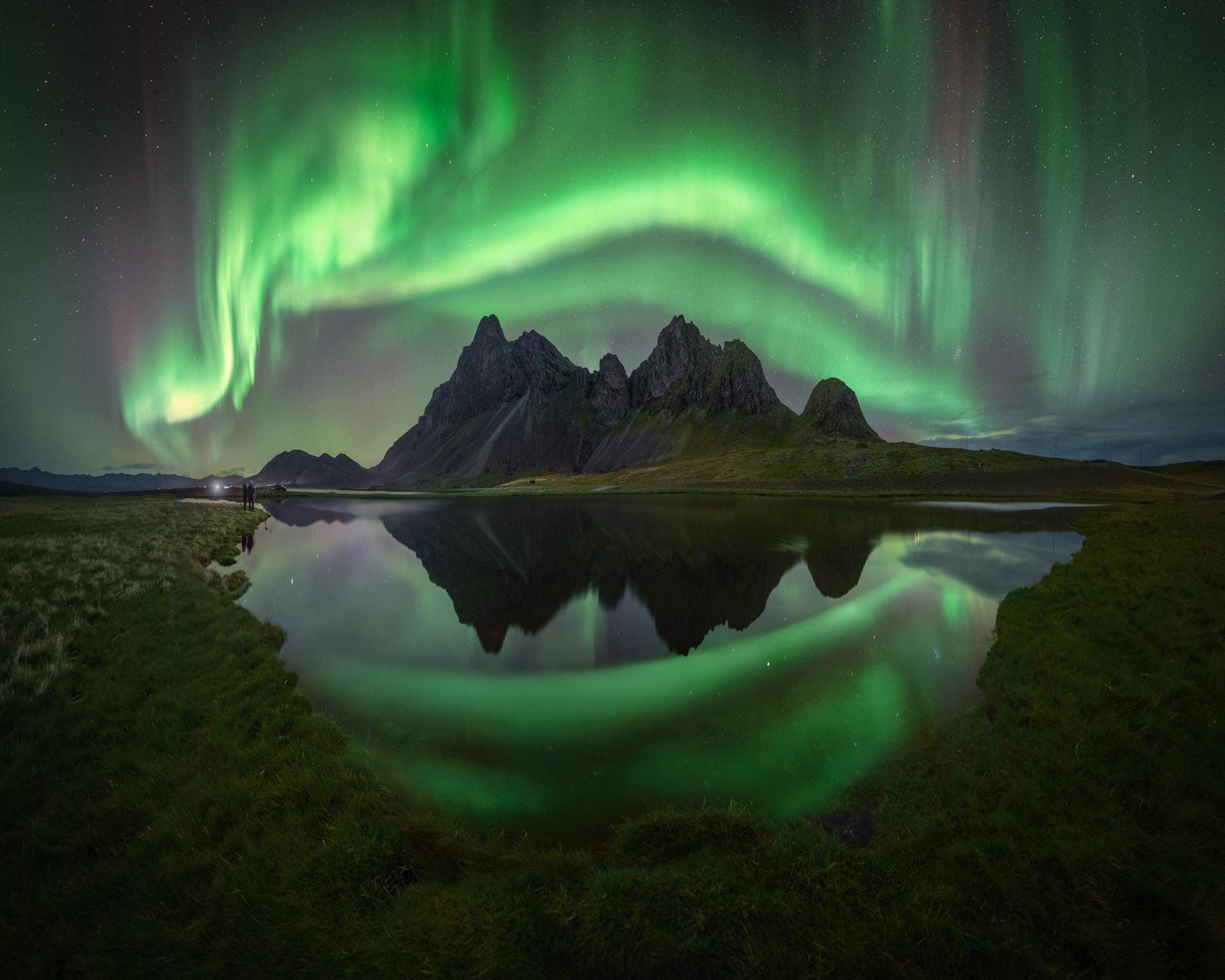 Green aurora borealis over a rocky landscape