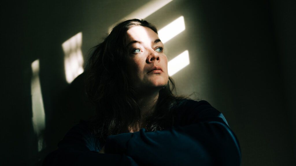 white woman looking up pensively