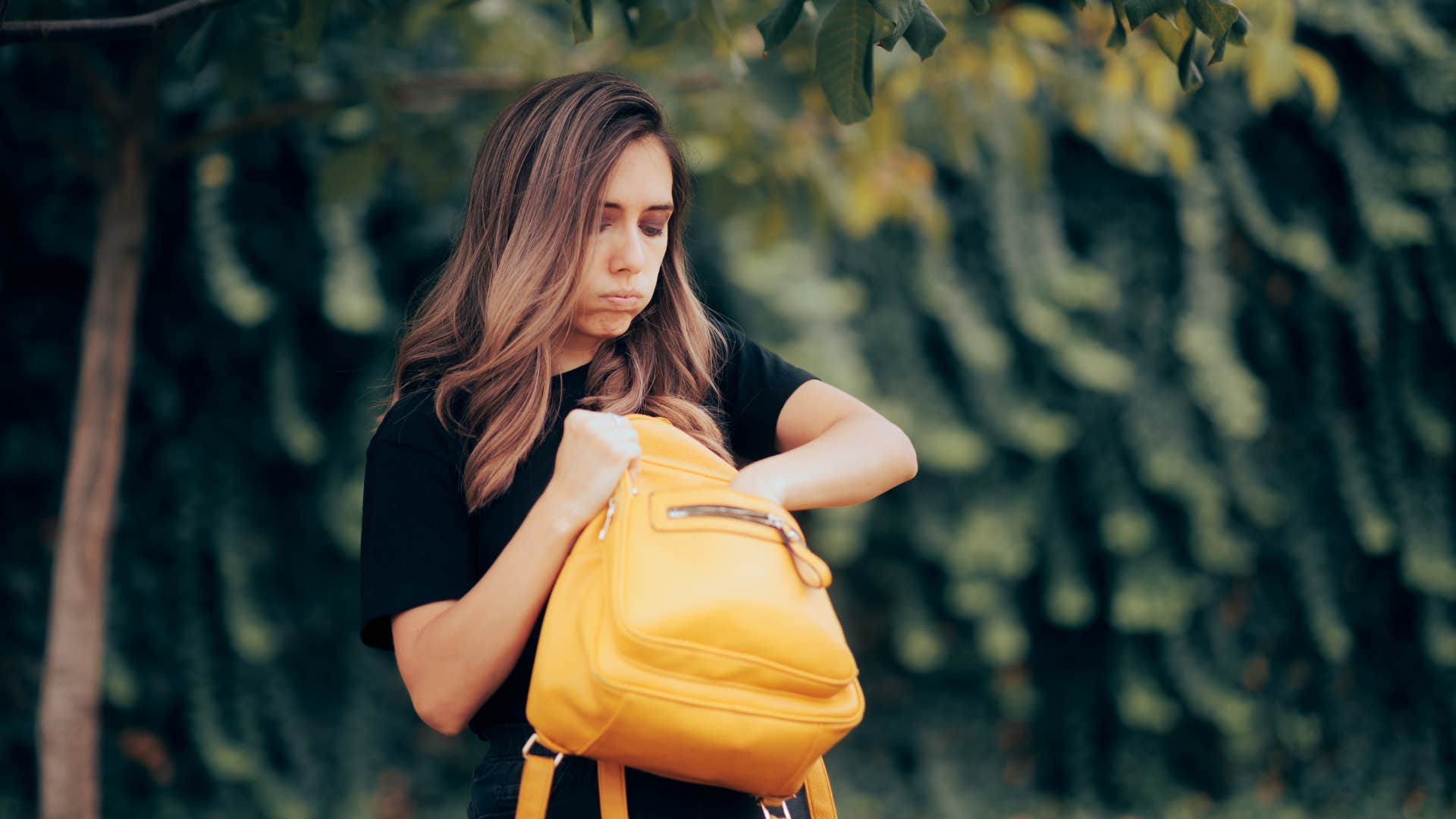 stressed woman looking through backpack
