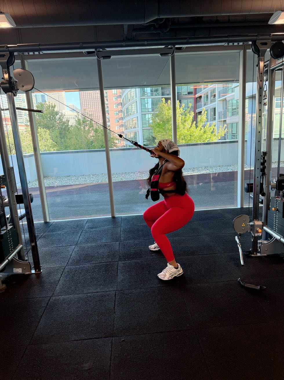 individual performing a squat exercise with resistance bands in a gym