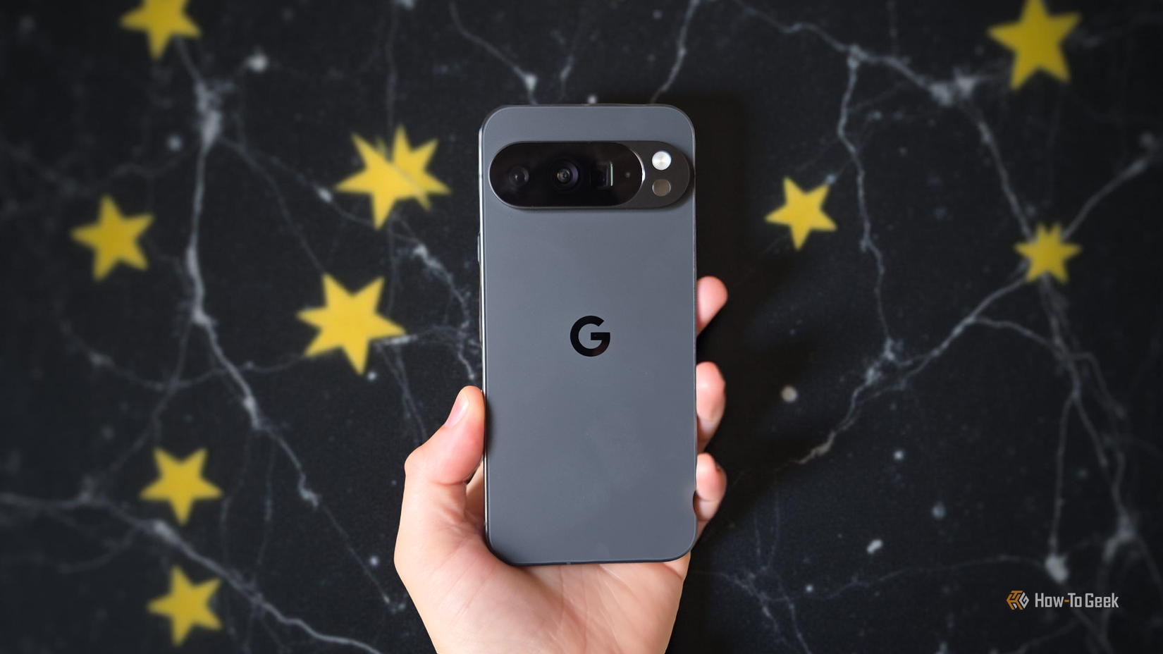 Pixel 10 Pro XL in hand with stars in the background. 