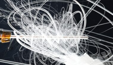 White streaks of motion swirl and swoop all over the image. At the middle of the image is a Teflon knitting needle.