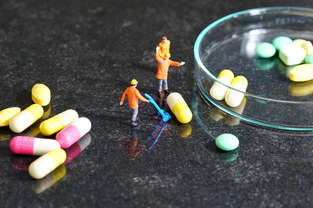 Miniature people - The worker at work with medicine pills